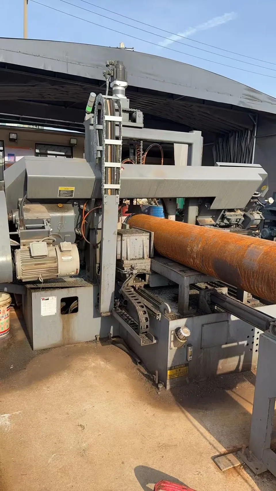 Saw cutting machine processing a large round steel bar